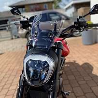 Nahaufnahme eines Motorrads mit modernem Design und klarem Windschild.