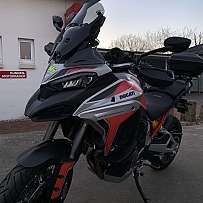 A Ducati Multistrada V4 motorcycle parked outside a building.