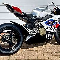 Ein silbernes Ducati Rennmotorrad mit auffälligen Grafiken und breiten Reifen.