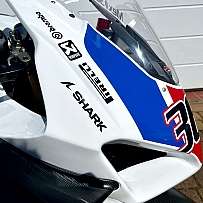 Detailaufnahme eines Motorrads mit auffälliger Rennlackierung und Logos.