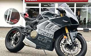 Ein schnittiges Ducati-Sportmotorrad, das vor einem Autohaus geparkt ist.