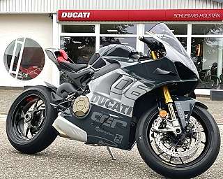 Ein schnittiges Ducati-Sportmotorrad, das vor einem Autohaus geparkt ist.
