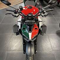 Ein sportliches Motorrad mit rot-grün-weißer Lackierung in einem Ausstellungsraum.