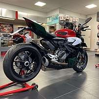 Ein Ducati Motorrad in einem Verkaufsraum mit Zubehör und Helmen.