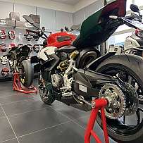 Ein sportliches Motorrad in einem Ausstellungsraum mit Helmen im Hintergrund.