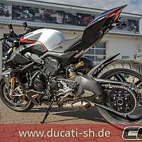 Ein modernes Ducati Motorrad mit sportlichem Design auf einem Parkplatz.