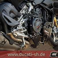 Detailaufnahme des Motors und Auspuffs eines Ducati Motorrads.