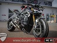 Ein sportliches Ducati Motorrad steht vor einem Geschäft.