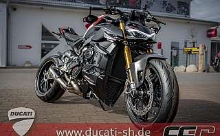 Ein sportliches Ducati Motorrad steht vor einem Geschäft.