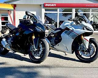 Zwei Ducati Motorräder, schwarz und weiß, vor einem Händler.