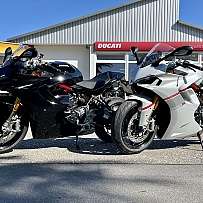 Zwei sportliche Ducati Motorräder vor einem Händlergebäude.