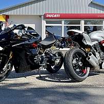 Zwei hochwertige Motorräder vor einem Ducati-Händler.