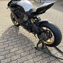 Ein Ducati Motorrad mit goldenen Felgen auf einem gepflasterten Platz.