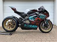 Ein Ducati Rennmotorrad mit auffälligem Design und goldenen Felgen.
