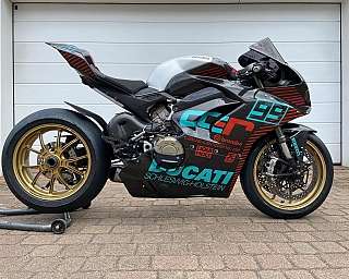 Ein Ducati Rennmotorrad mit auffälligem Design und goldenen Felgen.