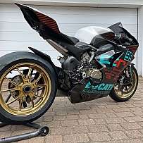 Ein sportliches Rennmotorrad mit auffälligen Farben und speziellen Reifen.
