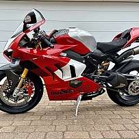 Ein rot-silbernes Ducati Panigale V4 Motorrad ist geparkt.