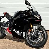 A sleek black Ducati Panigale V4 motorcycle parked on a driveway.