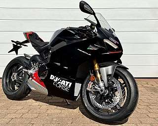 Ein schnittiges schwarzes Ducati Panigale V4-Motorrad, geparkt in einer Einfahrt.