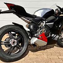 Seitenansicht eines Ducati V4 SP2 Motorrads auf einem gepflasterten Boden.