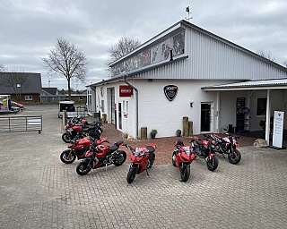 Ein Ducati Motorradgeschäft mit mehreren Motorrädern vor dem Gebäude.