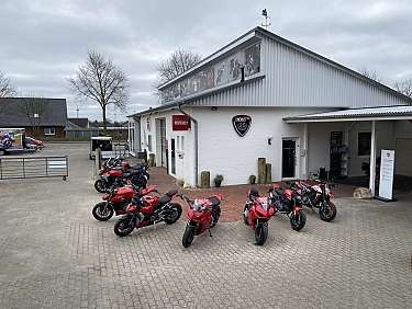 Ein Ducati Motorradgeschäft mit mehreren Motorrädern vor dem Gebäude.