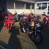Eine Gruppe von Motorrädern in einem Verkaufsbereich im Freien.