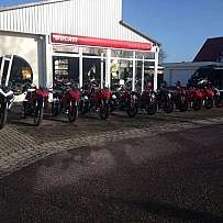 Eine Reihe von Ducati-Motorrädern vor einem Verkaufsraum.