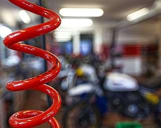 Ein roter Schlauch im Vordergrund einer Motorradwerkstatt.
